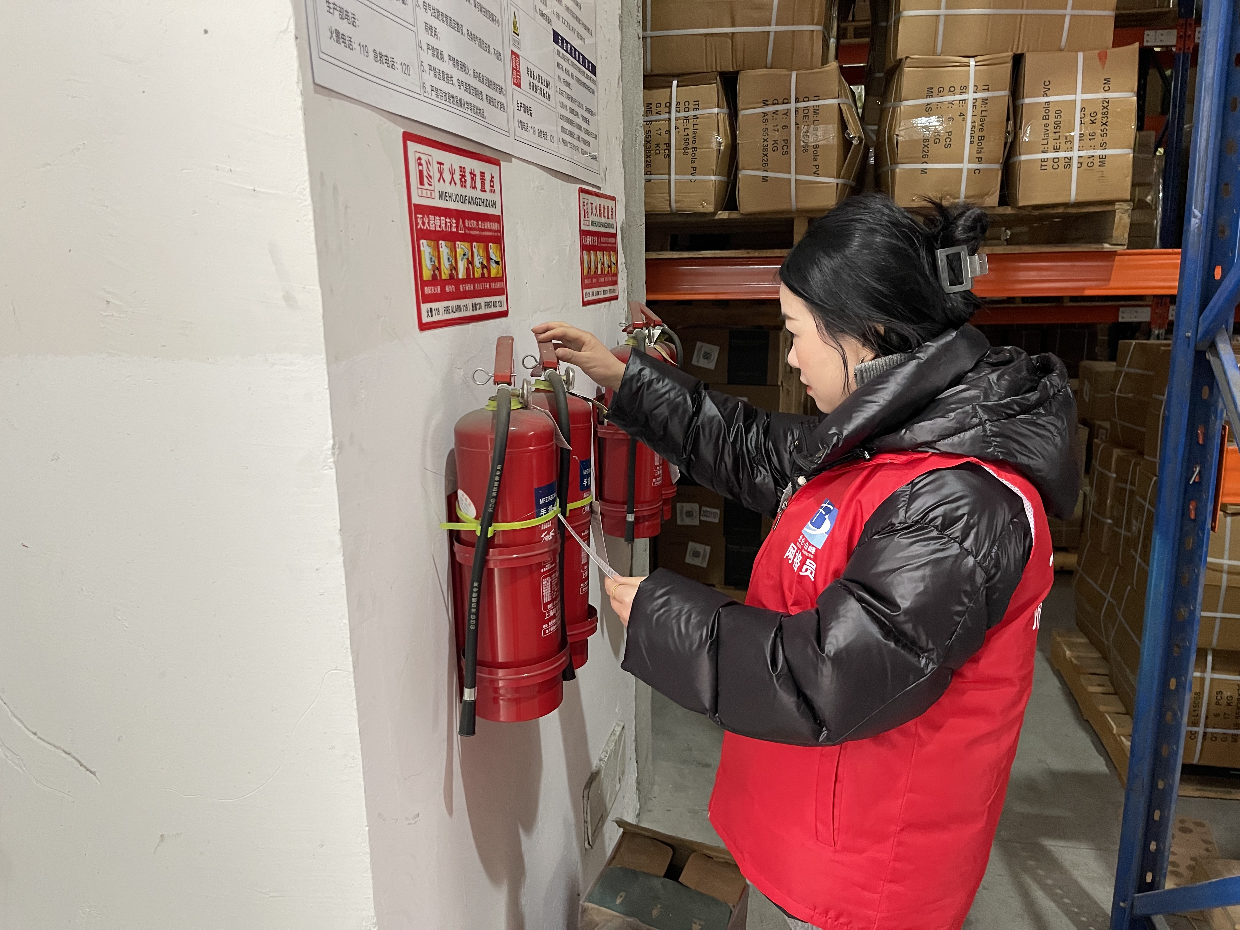 网格员检查灭火器（周怡 摄）.jpg