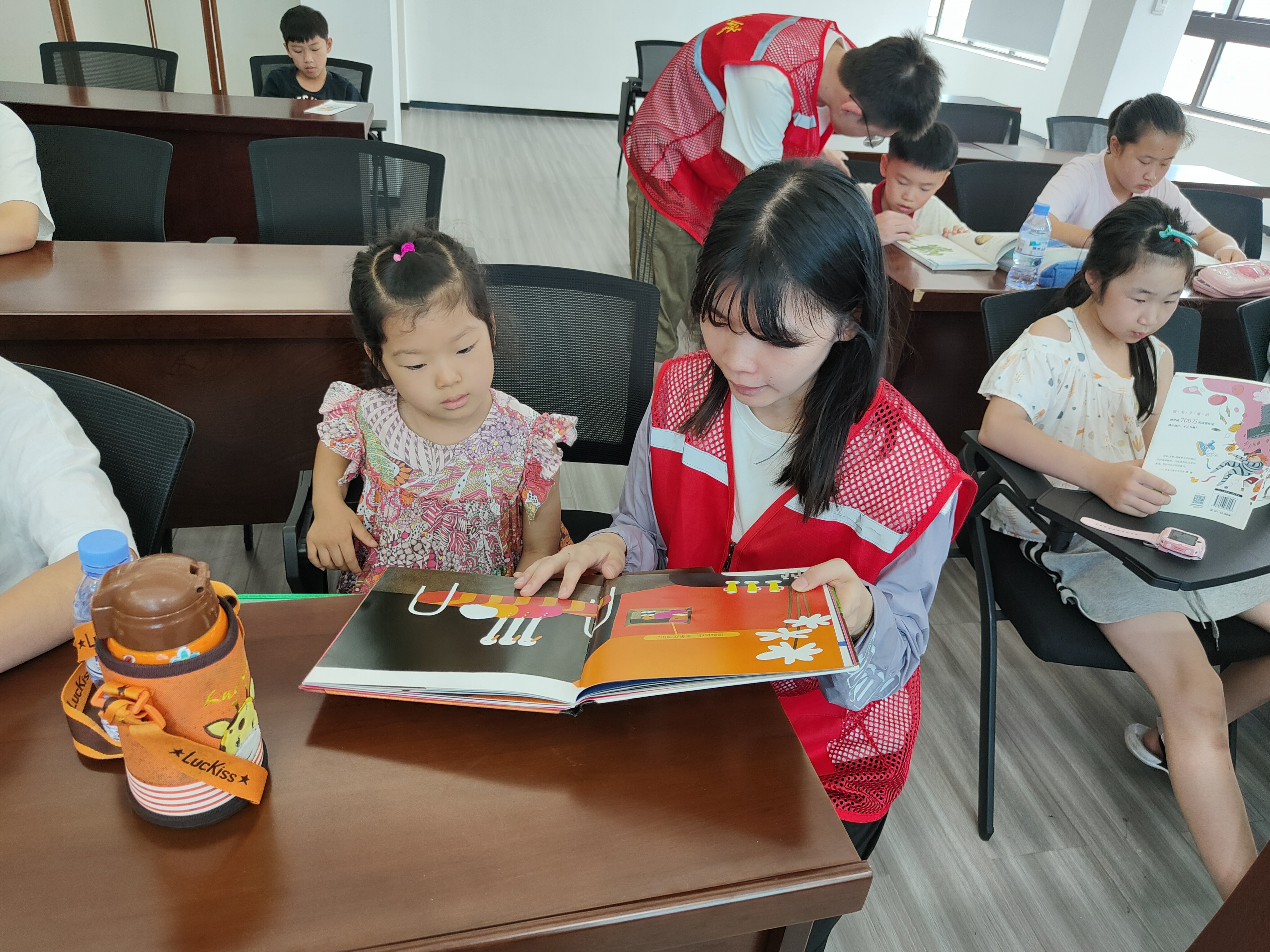 社区工作人员陪孩子们阅读书籍.jpg