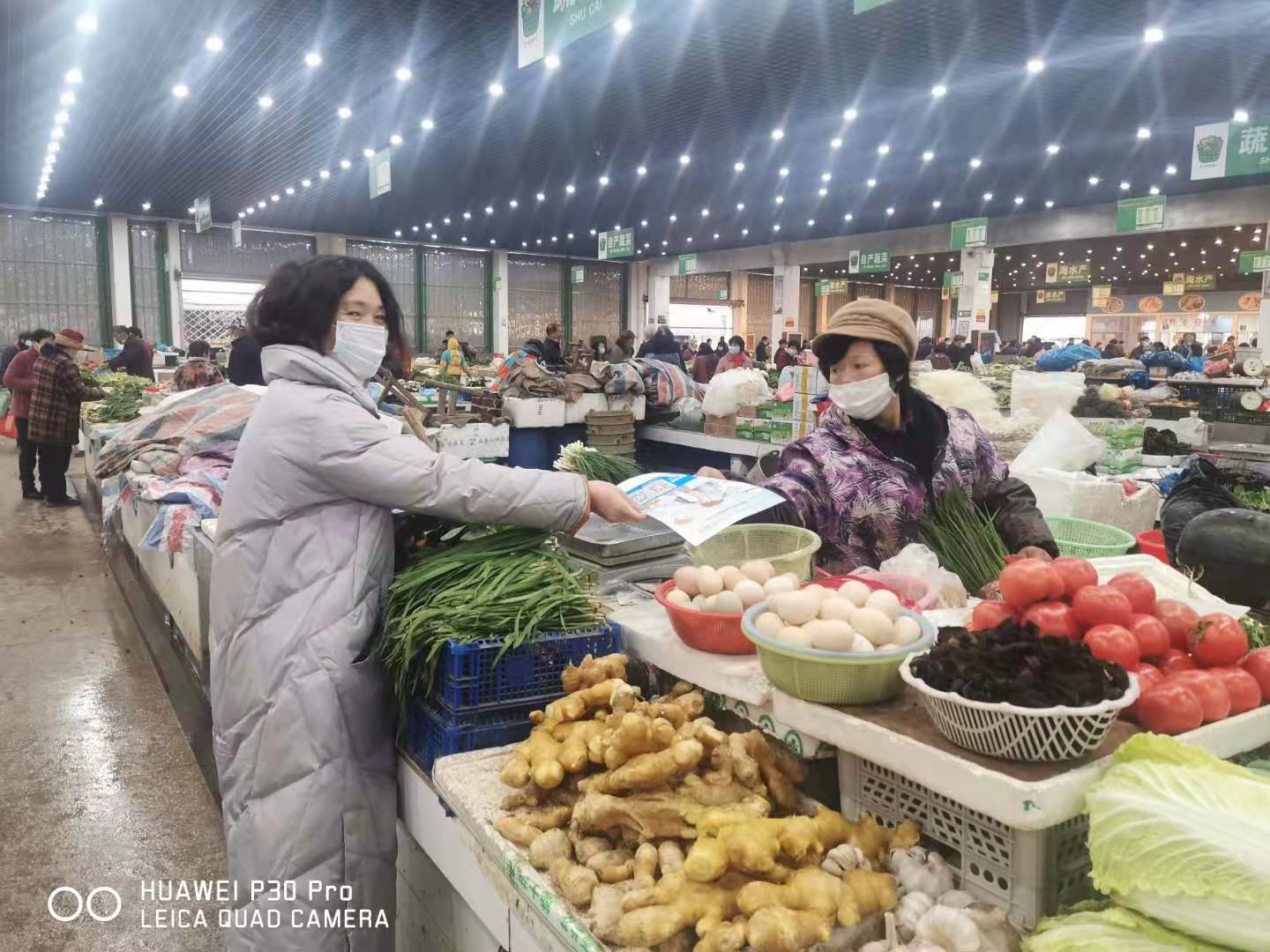 龙山镇宣传员在行动 龙山成校宣传引导员在范市农贸市场向摊贩分发防疫宣传图片.jpg
